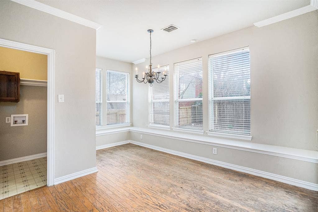 Unfurnished dining area featuring a notable chandelier and hardwood / wood-style floors