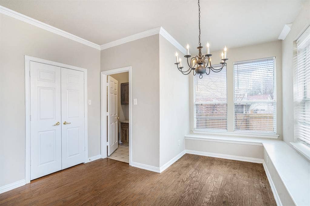 Unfurnished dining area featuring a notable chandelier, ornamental molding, and hardwood / wood-style floors