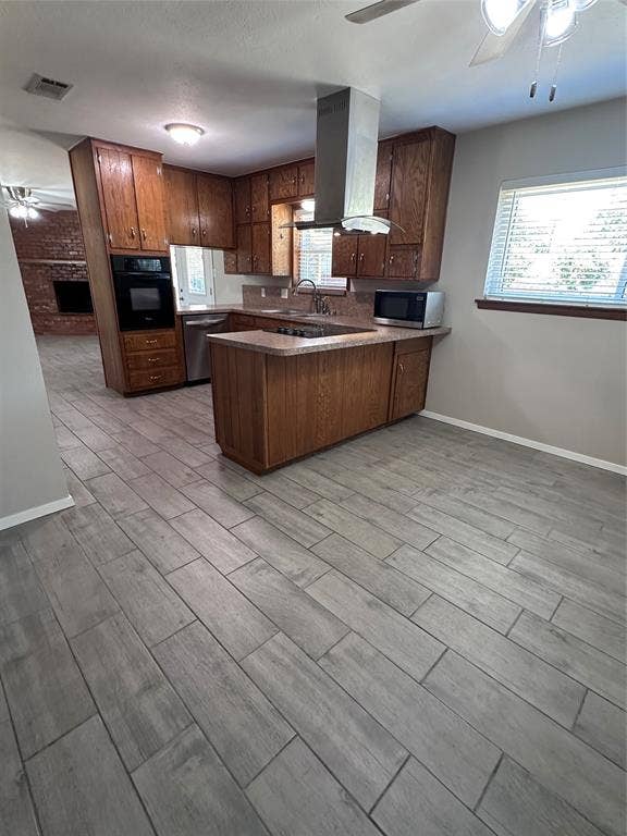 1321 Hurstview Drive, Hurst, TX 76053 Kitchen featuring wood cabinetry, stainless steel range hood, integrated oven, and a built-in breakfast bar