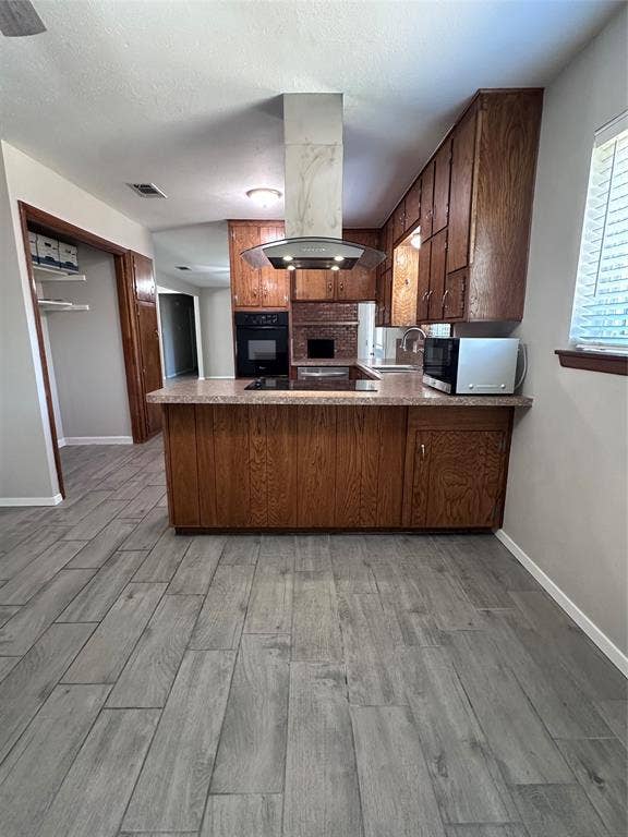 1321 Hurstview Drive, Hurst, TX 76053 Kitchen featuring wood cabinetry, stone-finish countertops, built-in oven, and a modern range hood