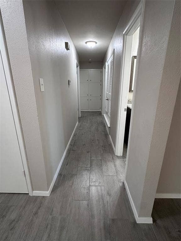 1321 Hurstview Drive, Hurst, TX 76053 Recessed lighting illuminates the hallway, featuring wood-look plank tile flooring, built-in cabinetry, and a louvered door