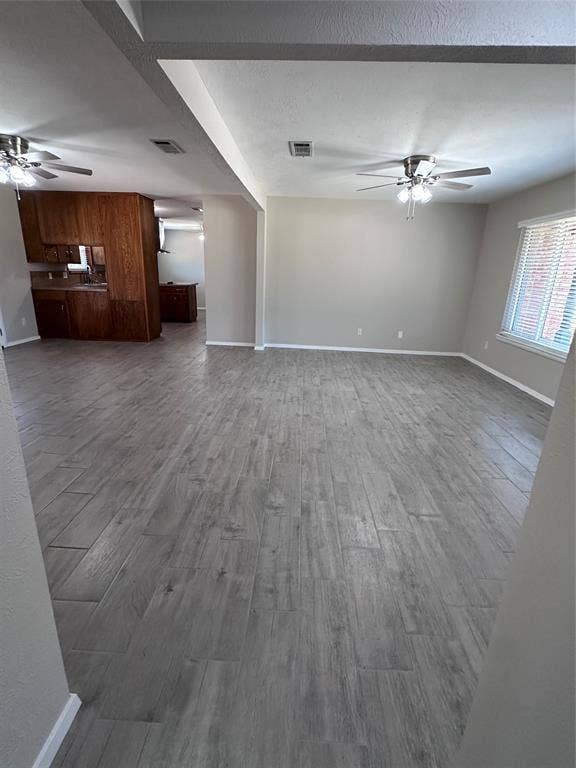 1321 Hurstview Drive, Hurst, TX 76053 Wood-finish flooring throughout, neutral wall paint, white trim, and ceiling fans with integrated lighting
