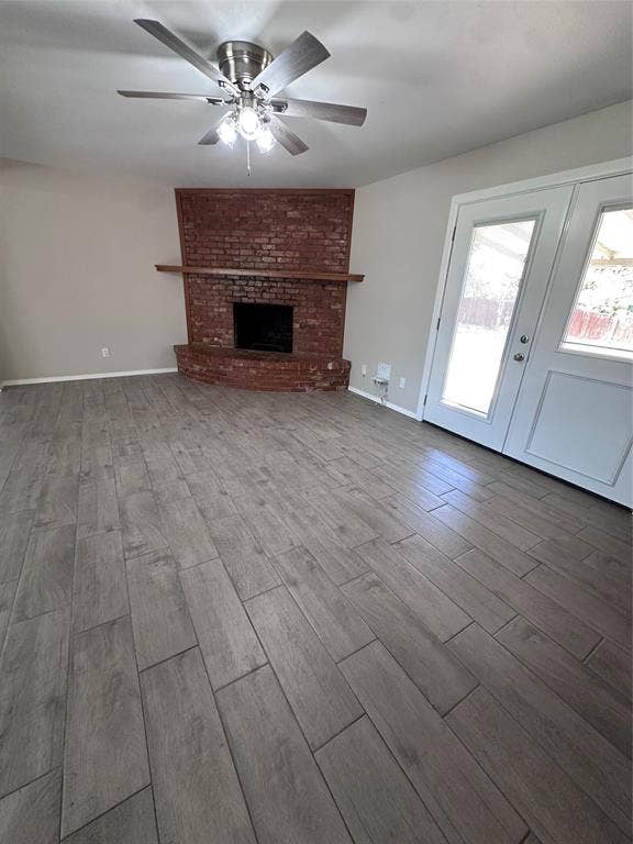 1321 Hurstview Drive, Hurst, TX 76053 Wood-finish flooring throughout, brick fireplace with a wood mantel, ceiling fan with integrated lighting, and French doors
