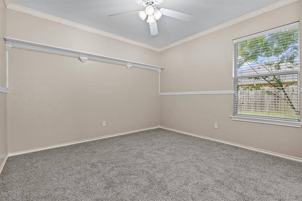 833 Greenwood Circle, Lindale, TX 75771 Bright secondary bedroom featuring neutral wall finishes, plush carpeting, ceiling fan with integrated lighting, and dual windows allowing natural light throughout the space
