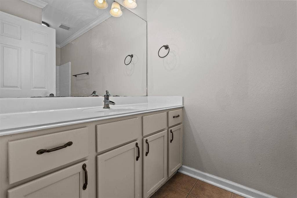 833 Greenwood Circle, Lindale, TX 75771 Spa-inspired primary bathroom vanity featuring a soft-finish cabinetry base with ample storage, a streamlined white countertop with integrated sink, and matte black hardware and faucet fixtures