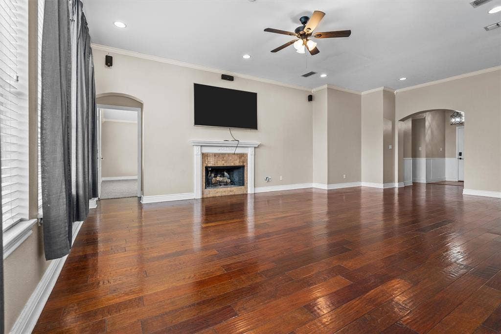 833 Greenwood Circle, Lindale, TX 75771 Spacious living area showcasing gleaming hardwood flooring, a ceiling fan with brushed metal finish, and recessed lighting throughout