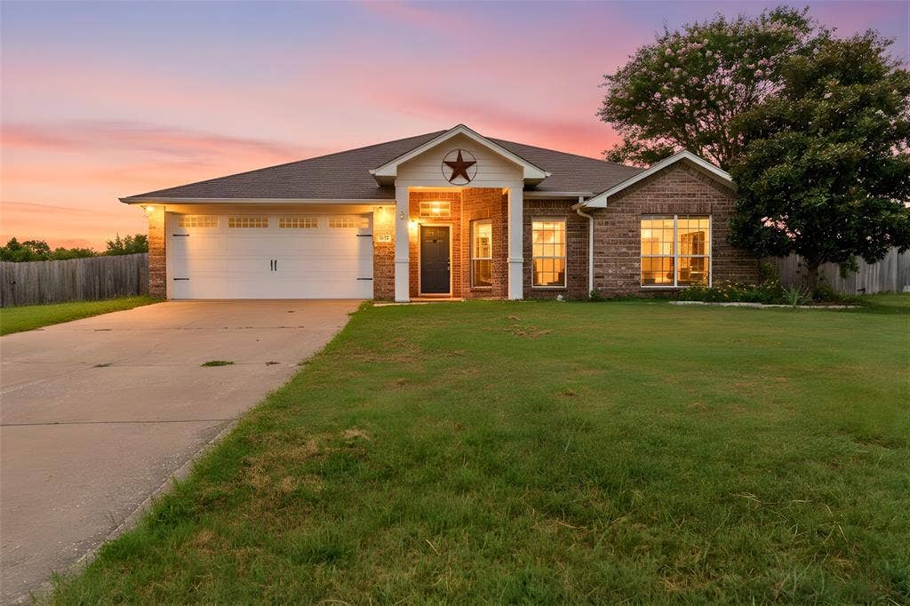 833 Greenwood Circle, Lindale, TX 75771 Charming brick residence featuring a welcoming front elevation with gabled roofline and decorative star accent