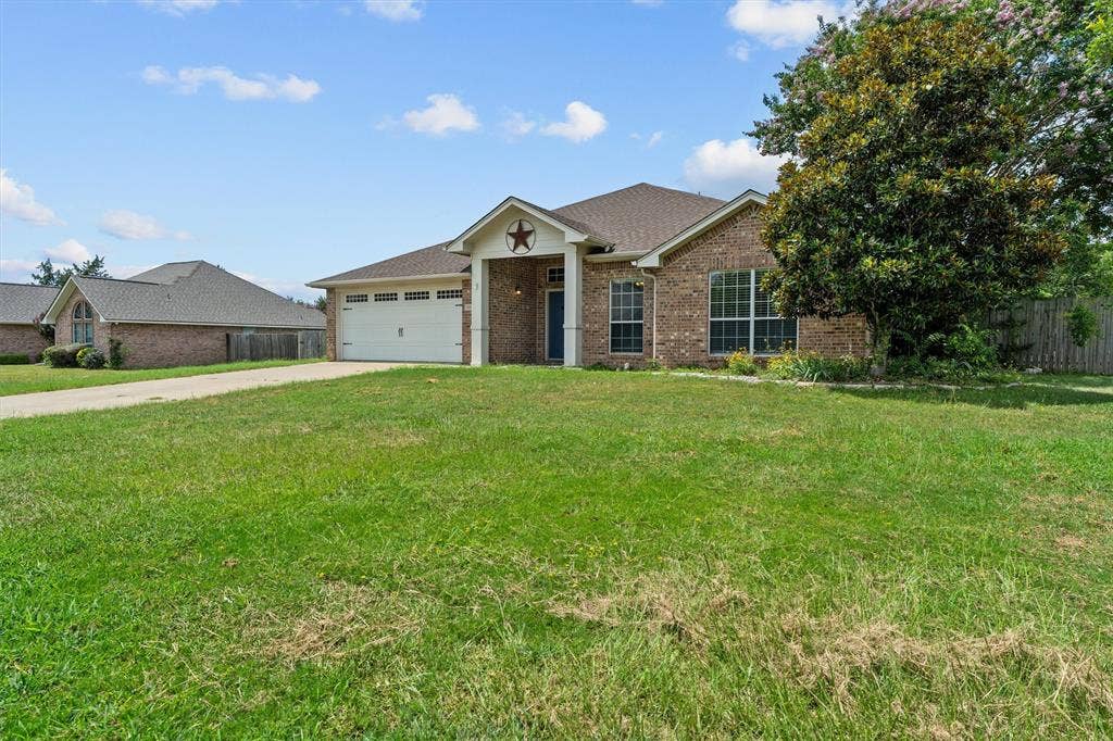 833 Greenwood Circle, Lindale, TX 75771 Brick exterior home situated on expansive manicured grounds featuring mature landscaping