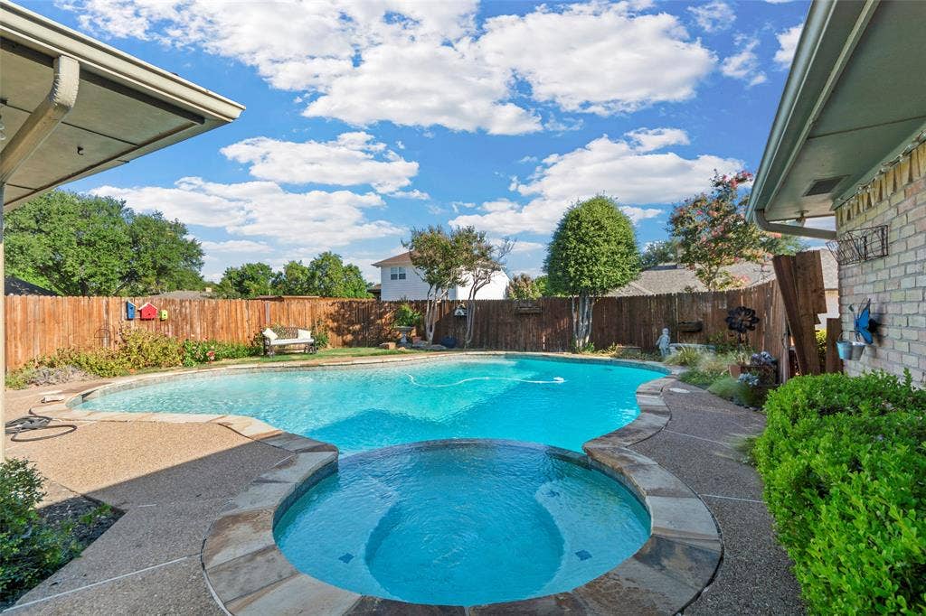 1116 Windsong Trail, Richardson, TX 75081 Backyard featuring a swimming pool, integrated spa, and aggregate deck with stone coping