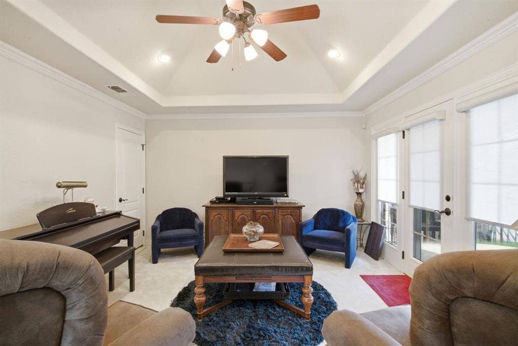 600 N Avalon Court, Granbury, TX 76048 Tray ceiling, recessed lighting, ceiling fan with integrated light fixture, and dual glass-paned doors leading onto the upstairs patio overlook Lake Granbury