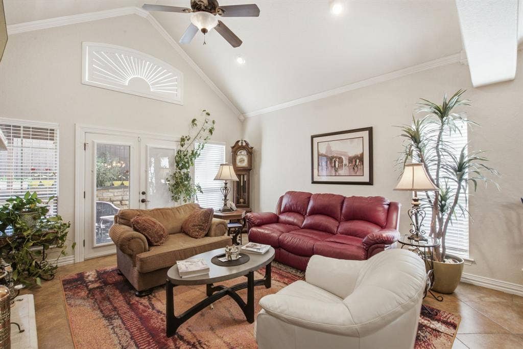 600 N Avalon Court, Granbury, TX 76048 Living area featuring a vaulted ceiling, sunburst window, tile flooring, and double glass-paneled doors