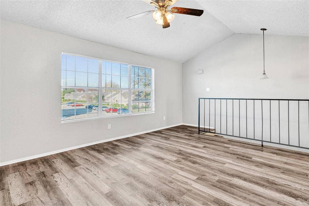 2500 E Park Boulevard, #P2, Plano, TX 75074 Welcome home to your beautiful spacious living area with vaulted ceilings, ceiling fan, wood-finish flooring, large multi-pane window, and a metal stair railing