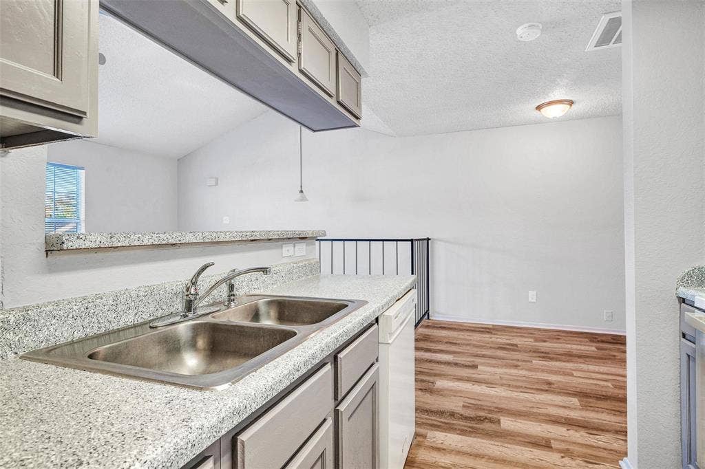 2500 E Park Boulevard, #P2, Plano, TX 75074 Kitchen featuring a double basin stainless steel sink, laminate countertops, and grey cabinetry overlooking the dinning area.