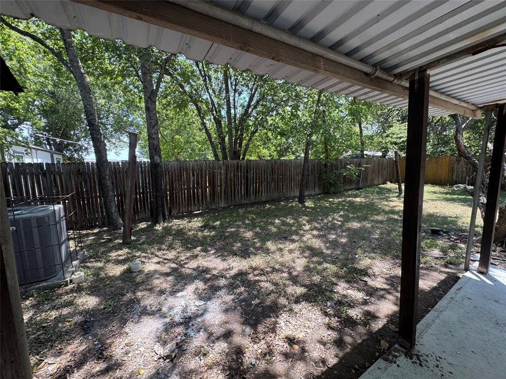 8105 White Settlement Road, White Settlement, TX 76108 Covered patio with a corrugated metal roof, wood support beams, and a concrete pad