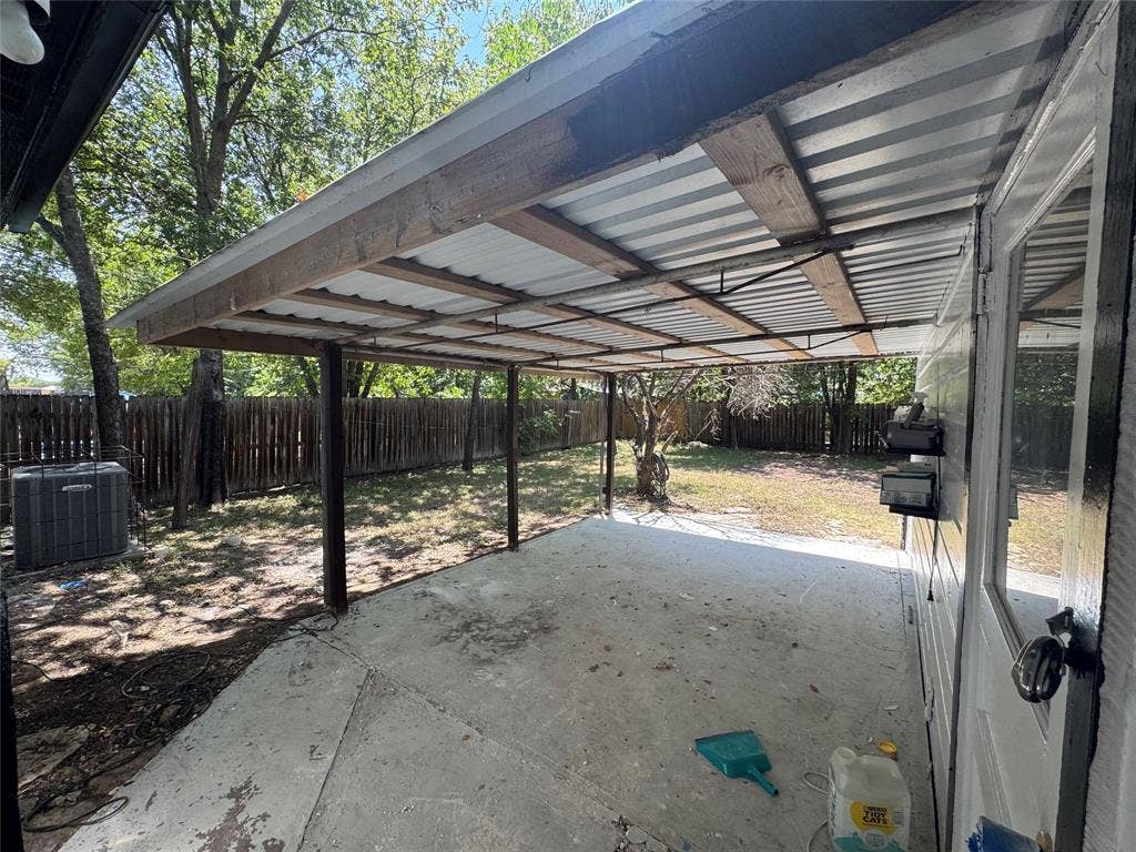 8105 White Settlement Road, White Settlement, TX 76108 Covered patio area with corrugated metal roofing, wood framing, and concrete slab
