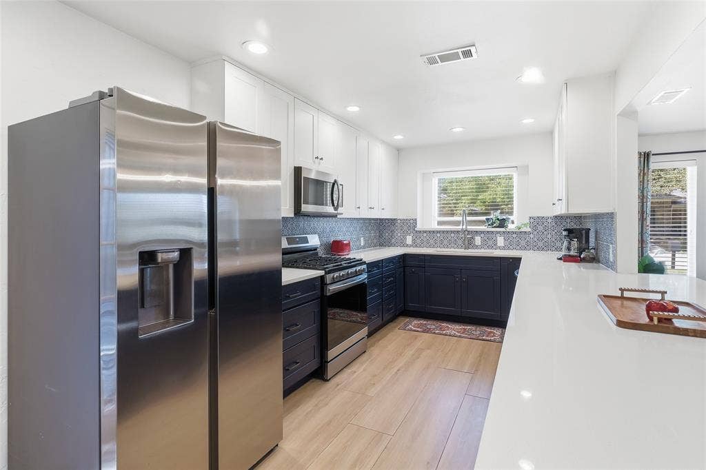 2808 Fountain Head Drive, Plano, TX 75023 Modern kitchen featuring stainless steel appliances, two-tone cabinetry, wood-finish flooring, recessed lighting, and a white countertop