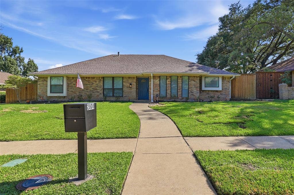 2808 Fountain Head Drive, Plano, TX 75023 Brick exterior with a gabled roof and a vibrant blue entry door