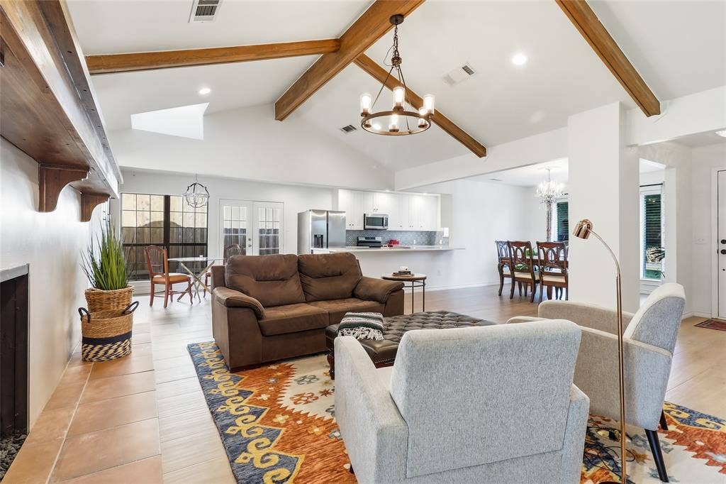 2808 Fountain Head Drive, Plano, TX 75023 Vaulted ceiling with exposed wood beams, skylight, recessed lighting, wood-finish flooring, and a built-in fireplace with a wood mantle