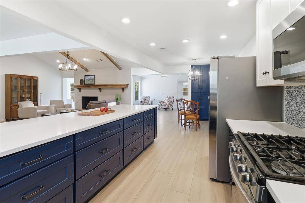 2808 Fountain Head Drive, Plano, TX 75023 Spacious kitchen island with extensive storage, stainless steel appliances, wood-finish flooring, recessed lighting, and an open concept layout