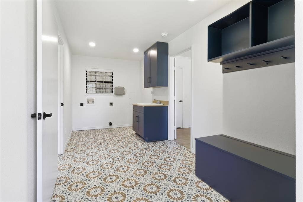 2808 Fountain Head Drive, Plano, TX 75023 Laundry room featuring patterned tile flooring, built-in cabinetry, a utility sink, and a window with blinds