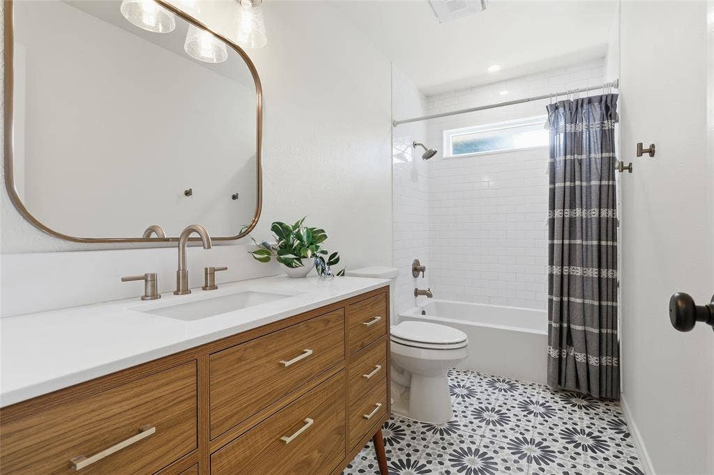 2808 Fountain Head Drive, Plano, TX 75023 Wood-finish vanity with a white countertop and undermount sink