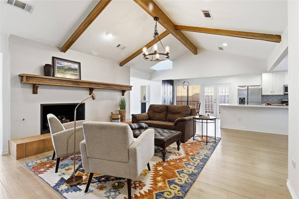 2808 Fountain Head Drive, Plano, TX 75023 Vaulted ceiling with exposed wood beams, wood-finish flooring, built-in fireplace, double French doors.