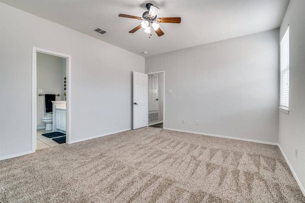 Spacious room featuring neutral carpet flooring and light-toned walls