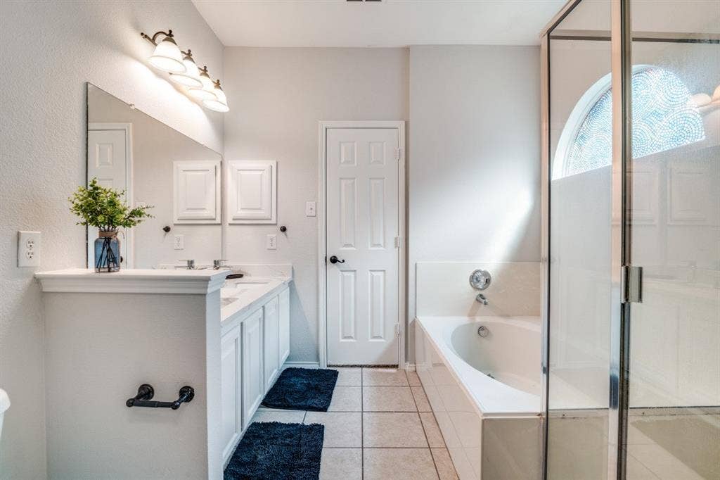 Dual vanity with white cabinetry, framed mirror, and integrated lighting