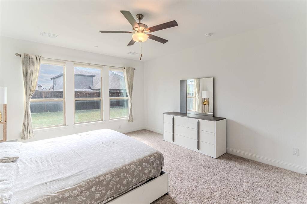2515 Bedford Road, Northlake, TX 76226 Wall-to-wall carpeting, three large windows with roller shades, and a ceiling fan with integrated lighting