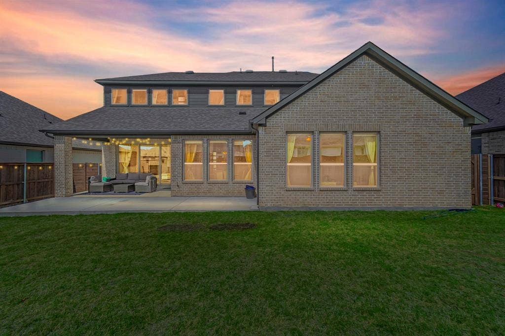 2515 Bedford Road, Northlake, TX 76226 Expansive backyard with a manicured lawn, concrete patio, covered outdoor living space, and a brick and siding exterior