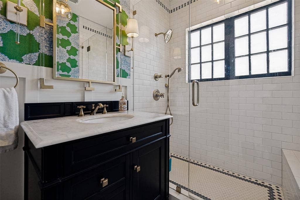 5610 Gaston Avenue, Dallas, TX 75214 Black vanity with a white countertop and brass hardware