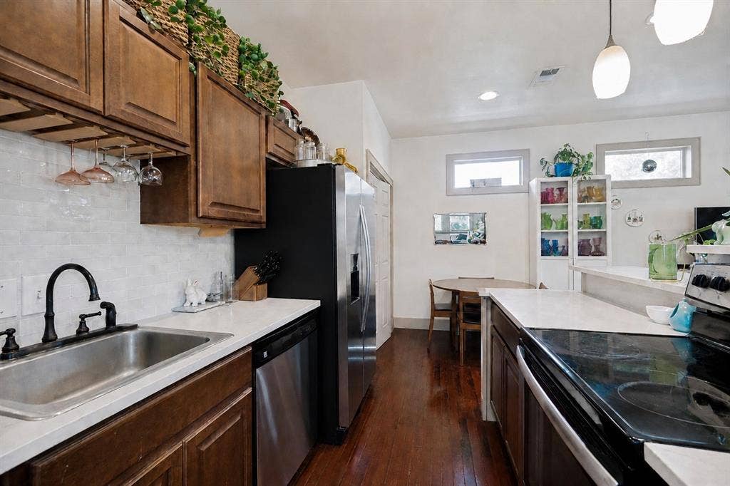 5610 Gaston Avenue, Dallas, TX 75214 Dark wood-finish flooring, ceiling fan with integrated lighting, built-in shelving, and a paneled interior door