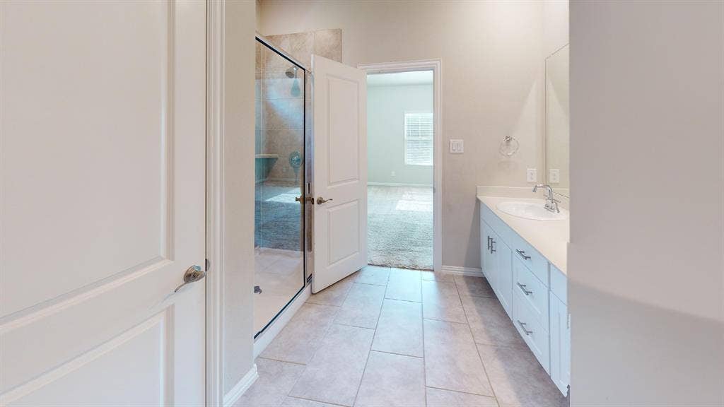 1508 Lannon Lane, Melissa, TX 75454 Full bathroom featuring a glass-enclosed shower with tiled walls, a single vanity with a solid surface countertop, an undermount sink, and tile flooring