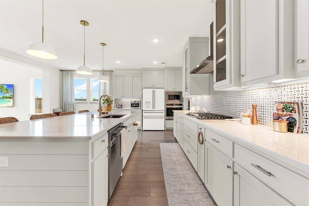 10067 Clover Forest Court, Frisco, TX 75035 A polished geometric backsplash catches soft under-cabinet glow beside custom shaker cabinetry. It’s ideal for chatting over evening wine while pasta simmers nearby.