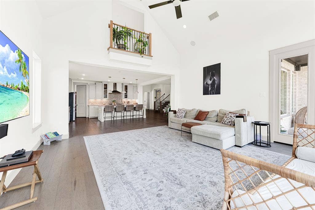 10067 Clover Forest Court, Frisco, TX 75035 An interior balcony looks down over the airy layout, connecting the upper level to the primary gathering space. Picture hosting friends for game night with seamless access to snacks in the kitchen nearby.