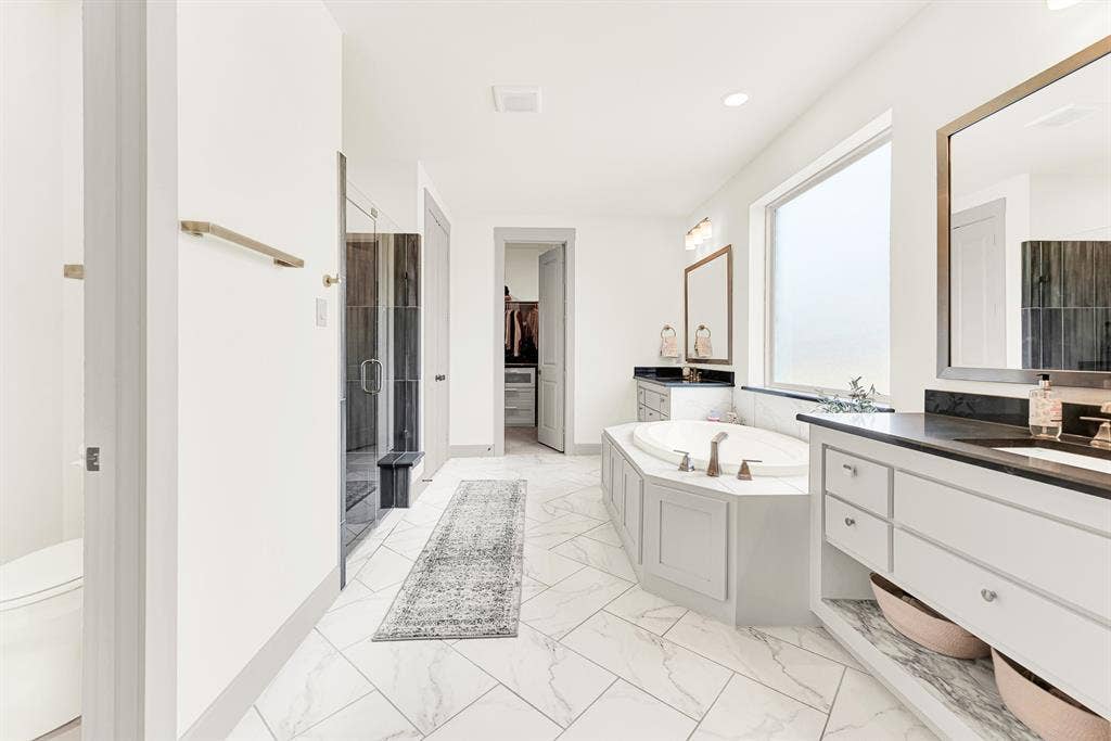 10067 Clover Forest Court, Frisco, TX 75035 Bright tile flooring laid in a dynamic diagonal pattern draws the eye toward a corner soaking tub. Ideal for washing away workday stress under warm water and quiet privacy.