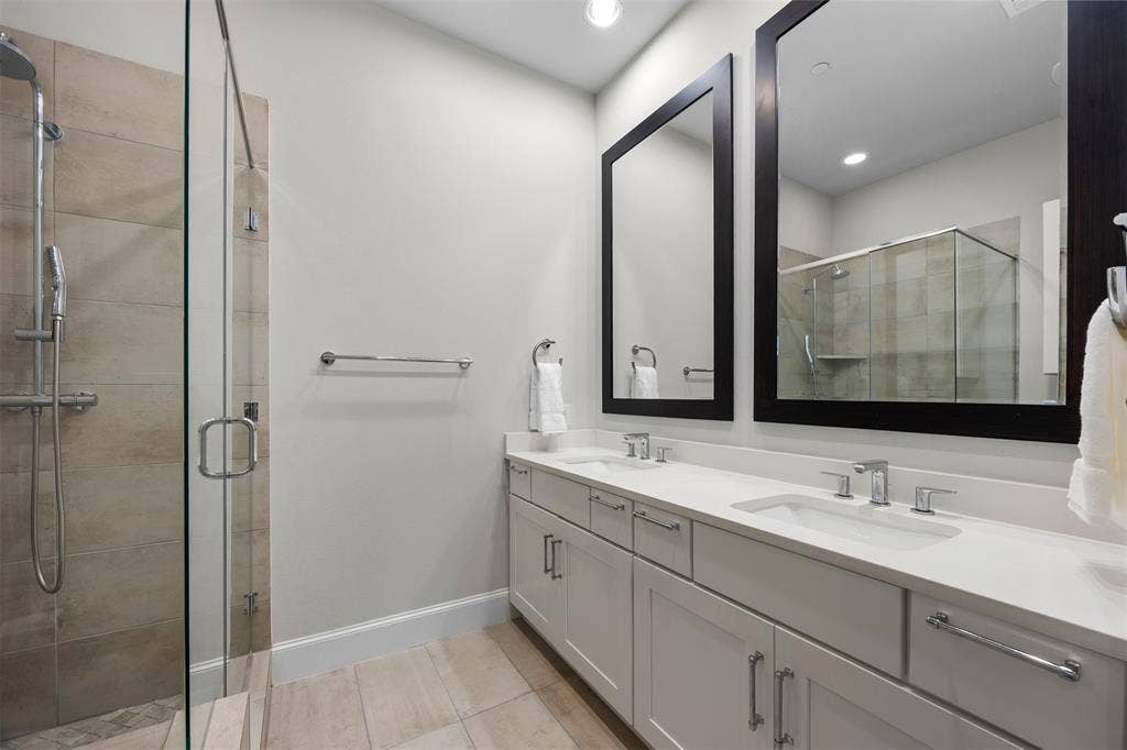 Dual vanity with undermount sinks, white countertops, and framed mirrors