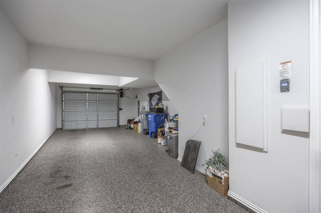 Enclosed garage featuring a concrete floor with speckled finish and an overhead garage door