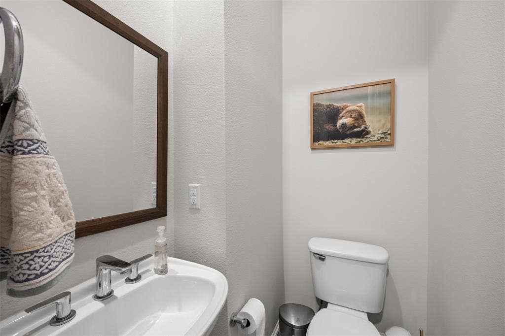 Wall-mounted vanity with a single basin, chrome faucet, and rectangular mirror with a wood-finish frame