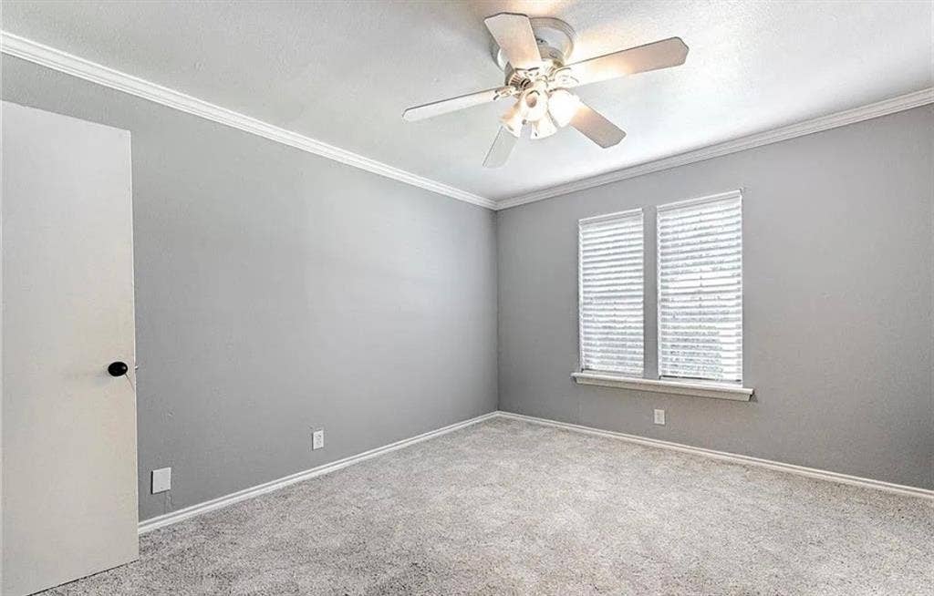 2601 Country Place, Carrollton, TX 75006 Spacious bedroom with neutral gray walls, neutral carpet flooring, and abundant natural light from dual shuttered windows