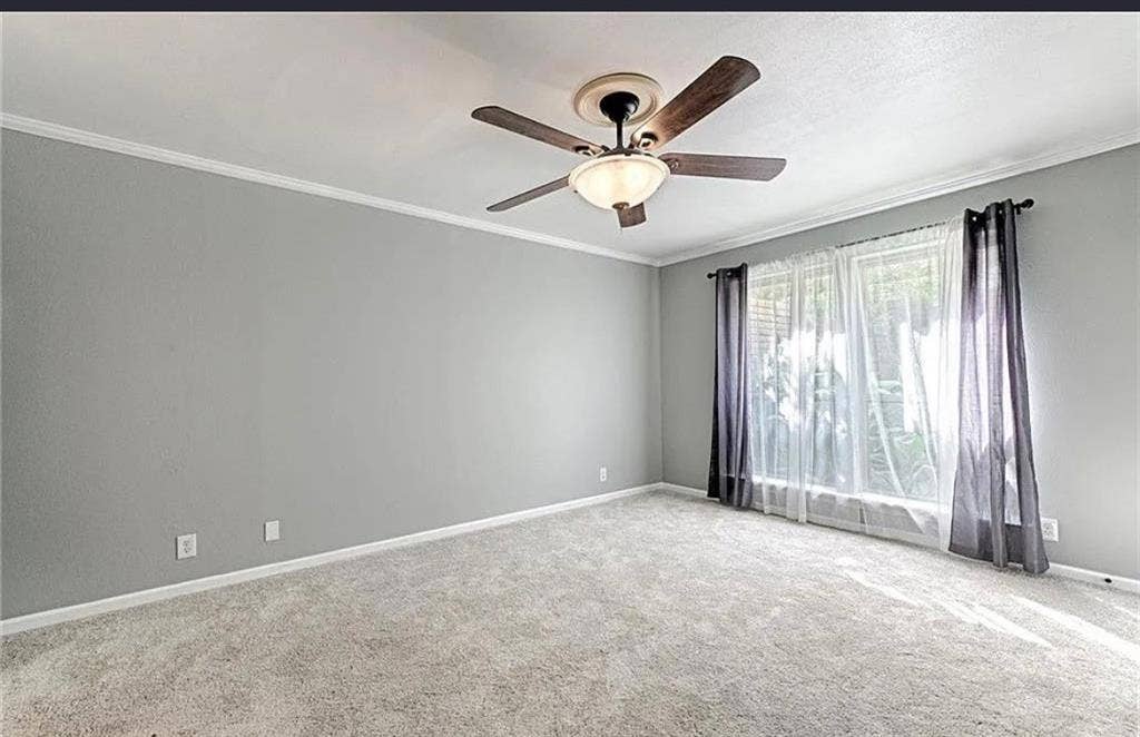 2601 Country Place, Carrollton, TX 75006 Spacious bedroom with neutral gray walls, soft neutral carpeting, ceiling fan with integrated lighting, and sliding glass doors with sheer and blackout drapery providing natural light control
