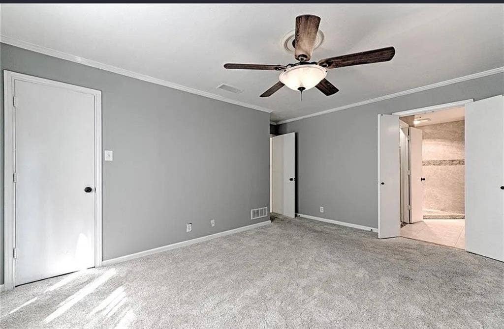 2601 Country Place, Carrollton, TX 75006 Spacious primary bedroom with neutral gray walls, neutral carpet flooring, ceiling fan with integrated lighting, and direct access to an ensuite bathroom