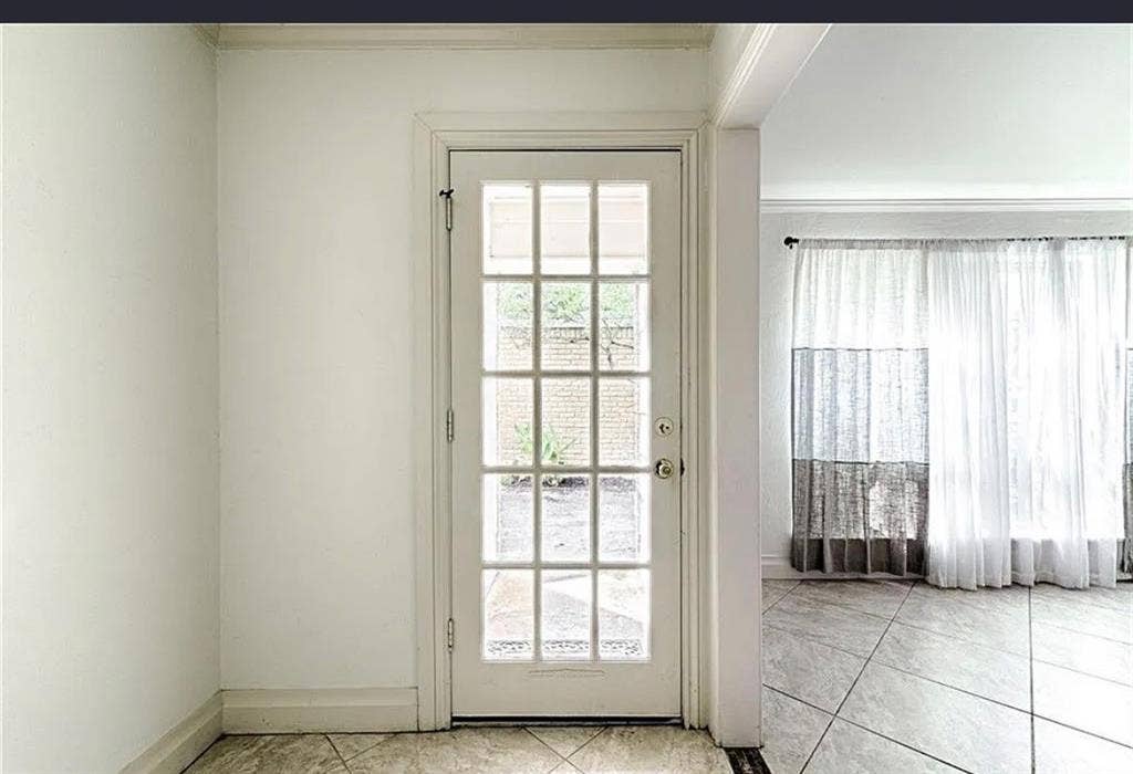 2601 Country Place, Carrollton, TX 75006 French paneled glass door with white trim, leading to a room featuring large windows with sheer curtains, and large-format tile flooring