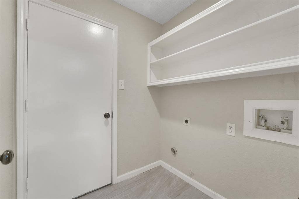 4001 Arrowcrest Lane, Garland, TX 75044 Bright, organized closet space featuring built-in shelving with integrated LED lighting, wood-finish flooring, and abundant storage capacity with clean white finishes and neutral wall tones