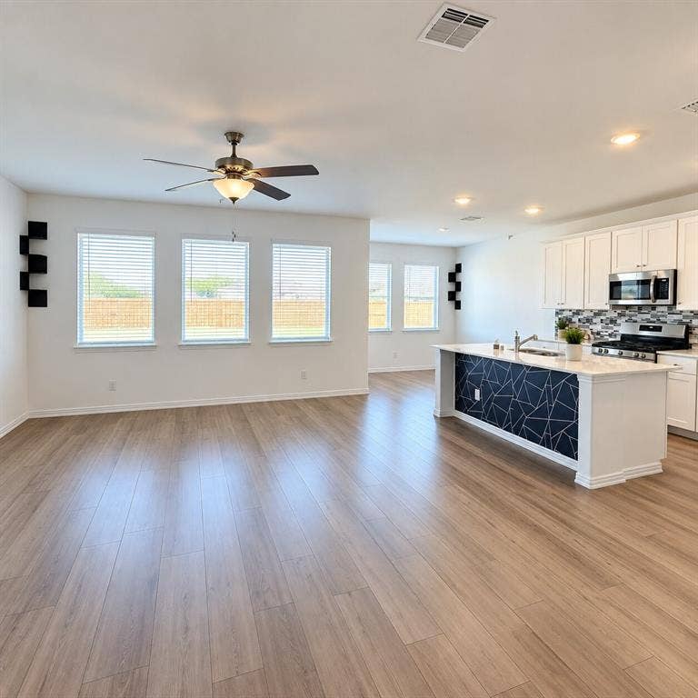 8432 Butterfly Lane, McKinney, TX 75071 Open-concept living space featuring wood-finish flooring, recessed lighting, and a ceiling fan