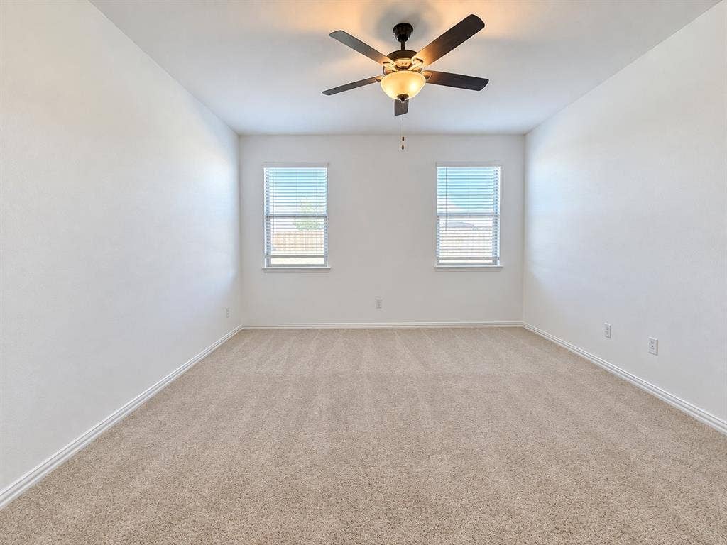 8432 Butterfly Lane, McKinney, TX 75071 Neutral-toned carpeting, white walls, and a ceiling fan with integrated lighting