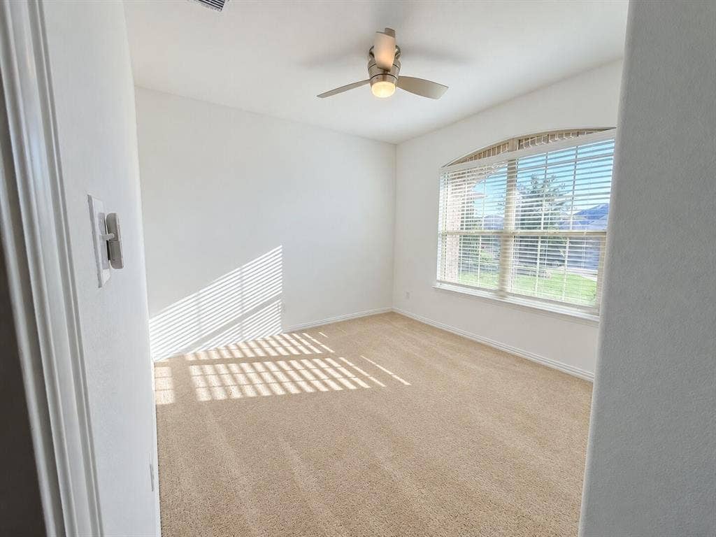 8432 Butterfly Lane, McKinney, TX 75071 Arched window with horizontal blinds, neutral carpeting, and a ceiling fan with integrated lighting