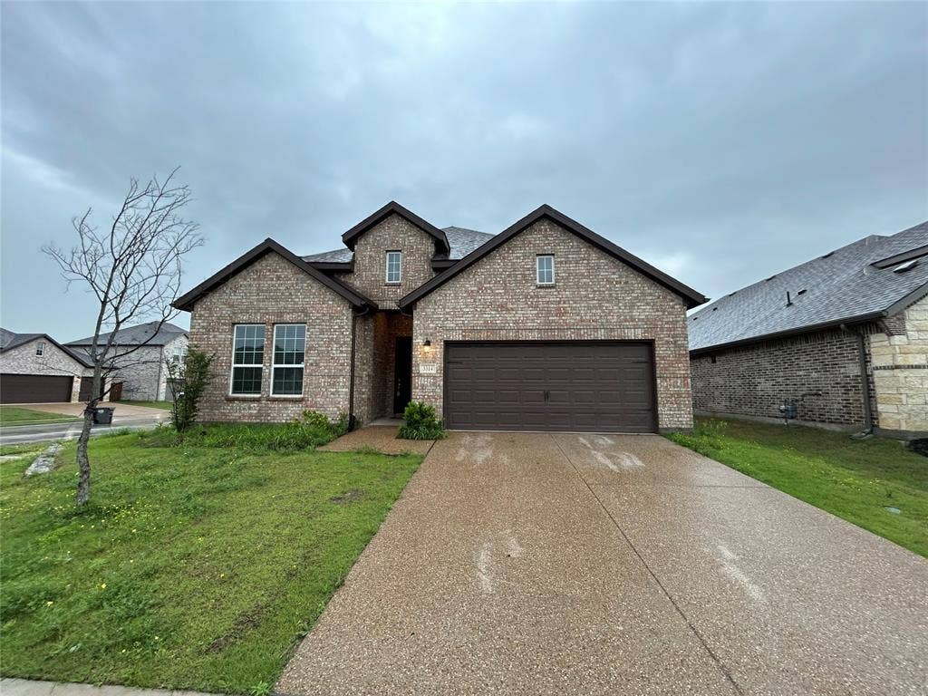 3314 Willena Road, Melissa, TX 75454 Brick Colonial home featuring a two-car attached garage with dark finish doors, manicured front lawn, and a concrete driveway