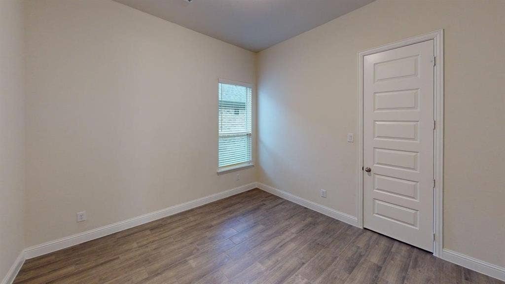 3314 Willena Road, Melissa, TX 75454 Bright corner bedroom with wood-finish flooring, large window with natural light, and smooth five-panel closet door