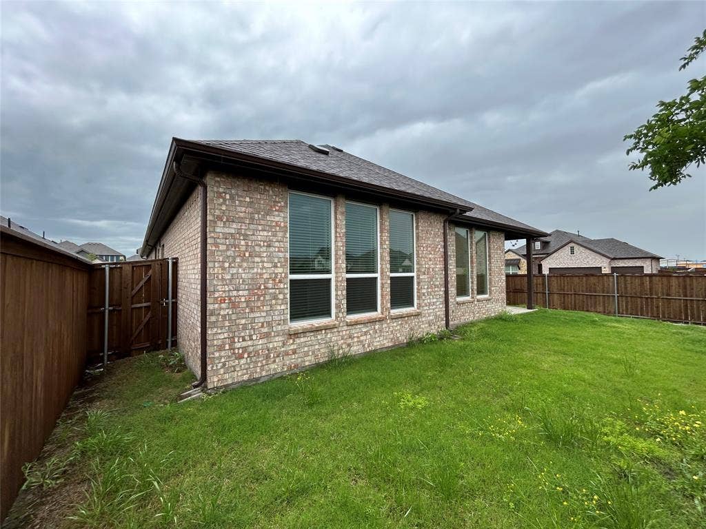 3314 Willena Road, Melissa, TX 75454 Expansive lawn area with a wood privacy fence and a gated entry